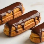 Éclairs au chocolat faits maison, pâtisserie française garnie de crème onctueuse et nappée d’un glaçage au chocolat brillant